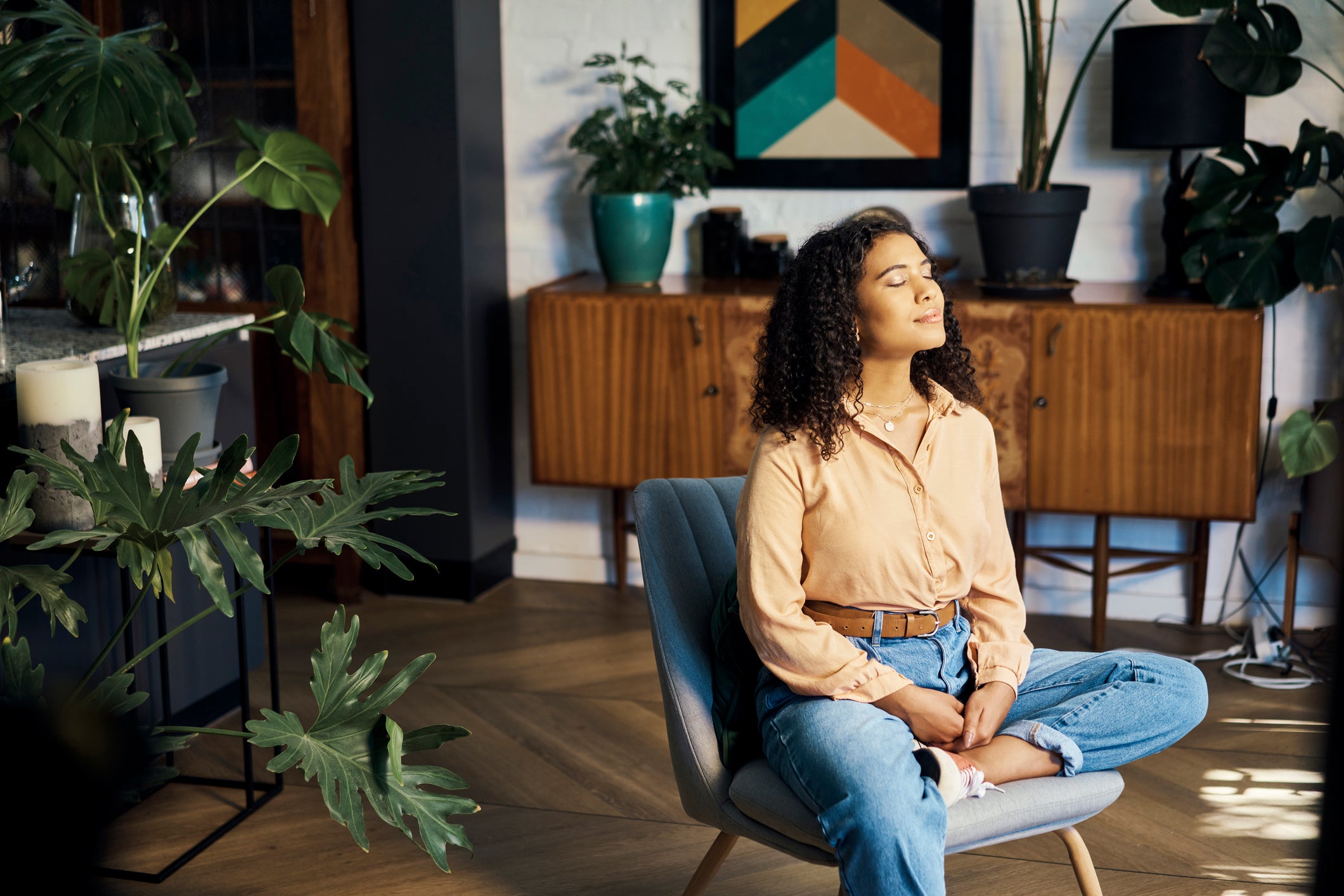 Woman sitting on a chair facing sunlight and smilling