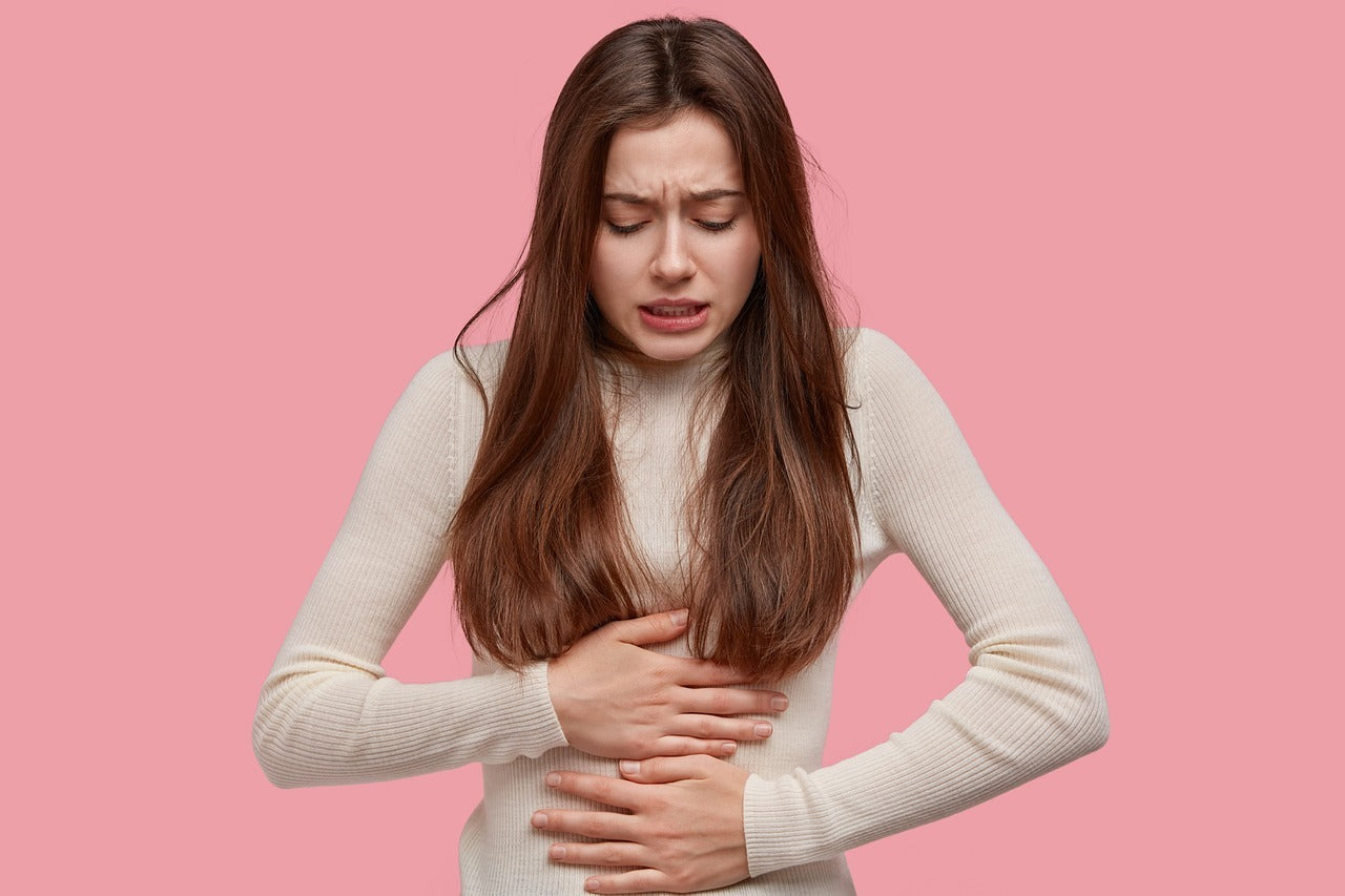 A woman holding her stomach due to period cramps