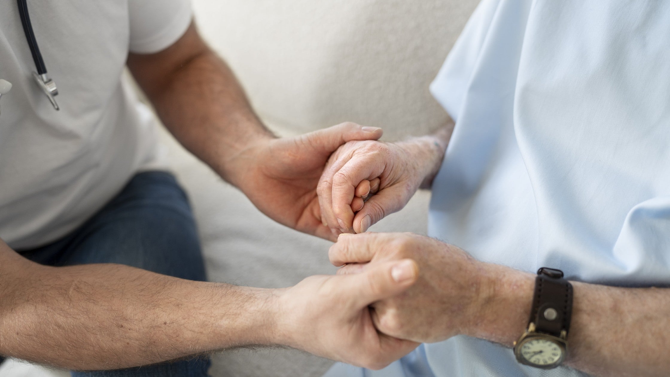 Doctor holding hands of a old person to represent support and provide comfort
