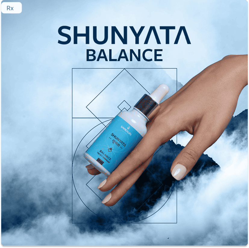A hand holding a Shunyata Balance dropper bottle against a misty blue mountain background.