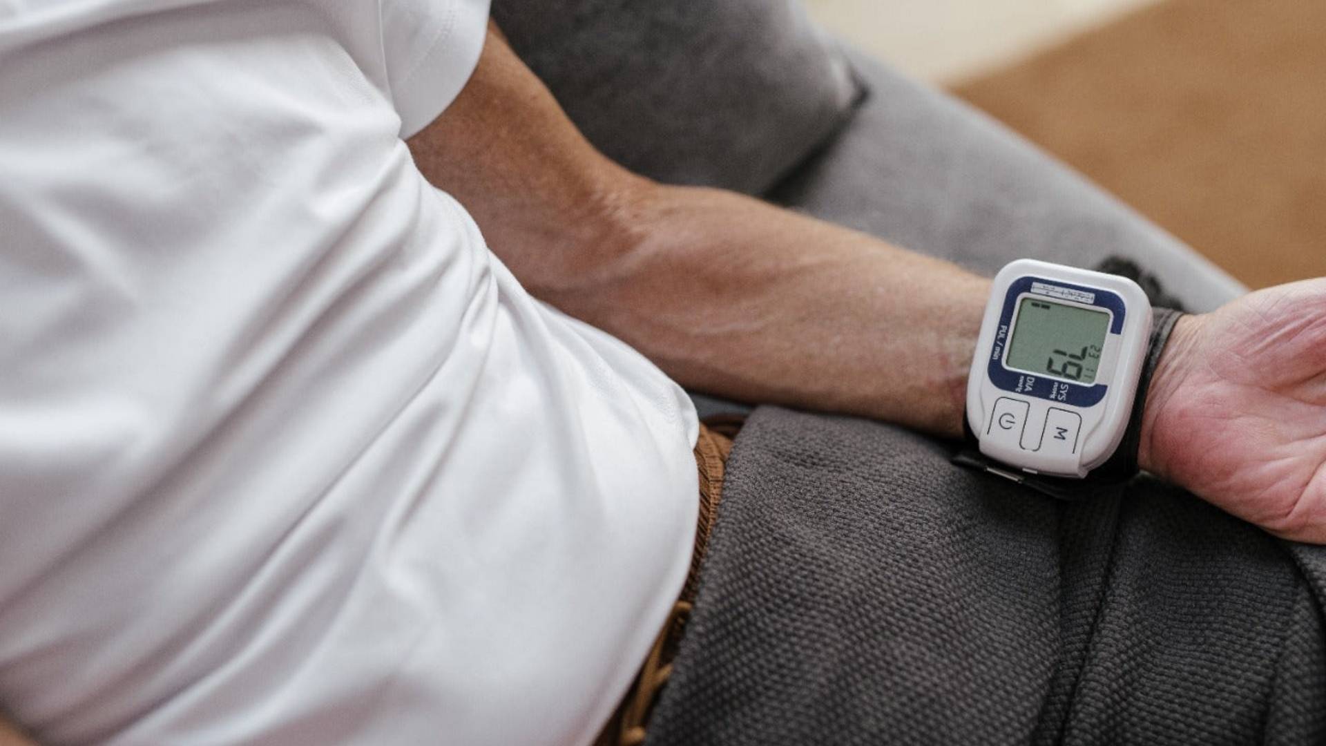 A man with a blood pressure machine tied on his wrist, contemplating the use of cannabis for managing high BP