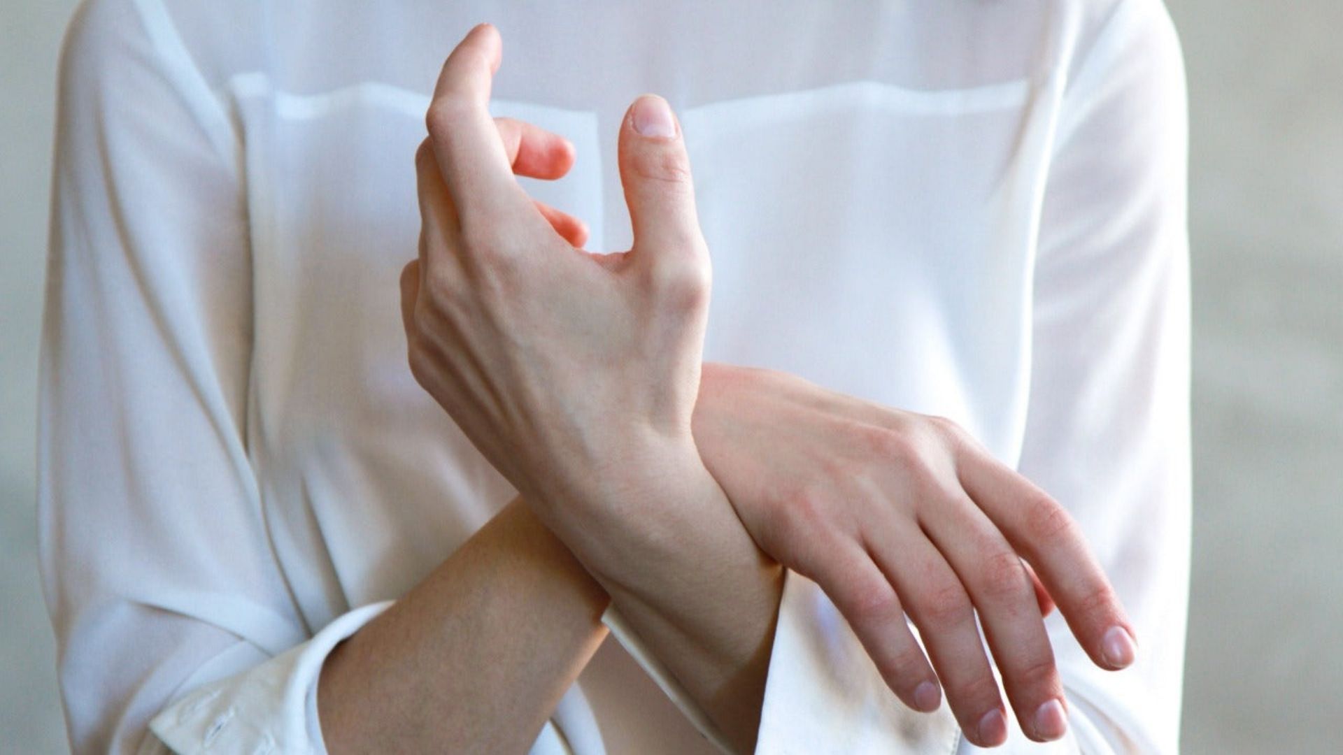 A woman holding her hands together, reflecting on her experience with fibromyalgia and cannabinoid medication
