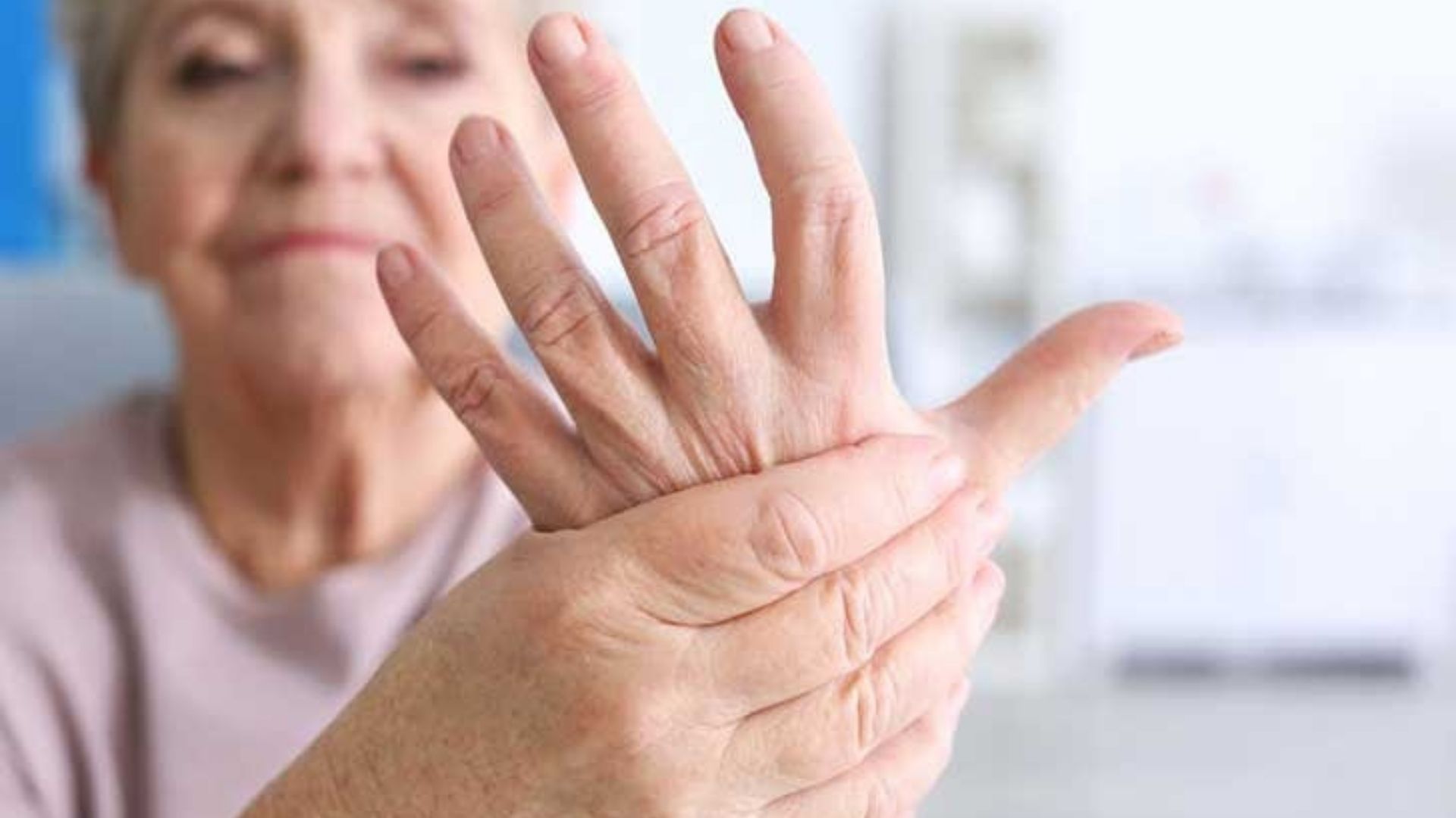 An image of an old woman showing her hands suffering from joint pain due to arthritis showing pain perception