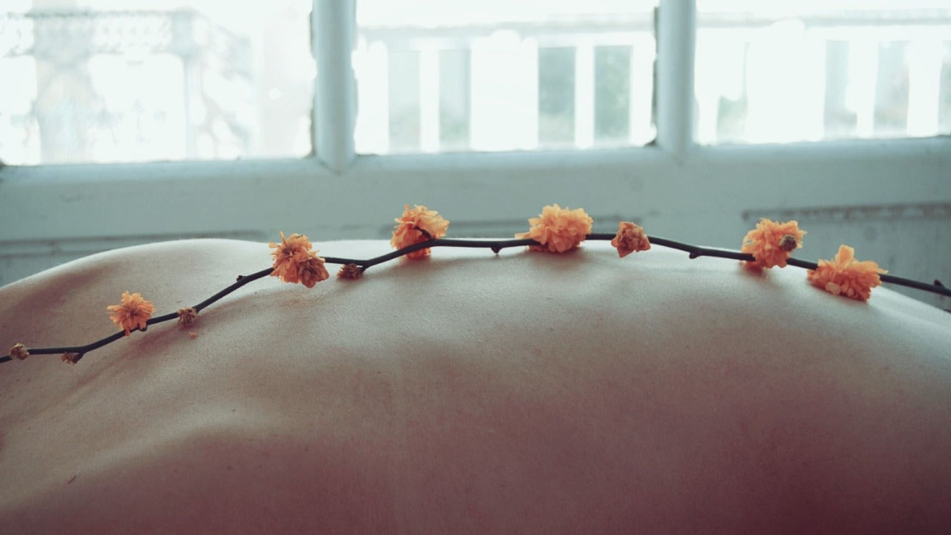 A human back adorned with flowers, representing natural remedies related to cannabinoid treatment for psoriasis